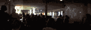 Panoramic photograph of the author's work and a rapt audience at the 'New York Underground meets Berlin Underground' event. The precursor work to Ruins in ASCII was projected during this event at the vacant Postdamer Platz U-Bahn station. Thumbnail.